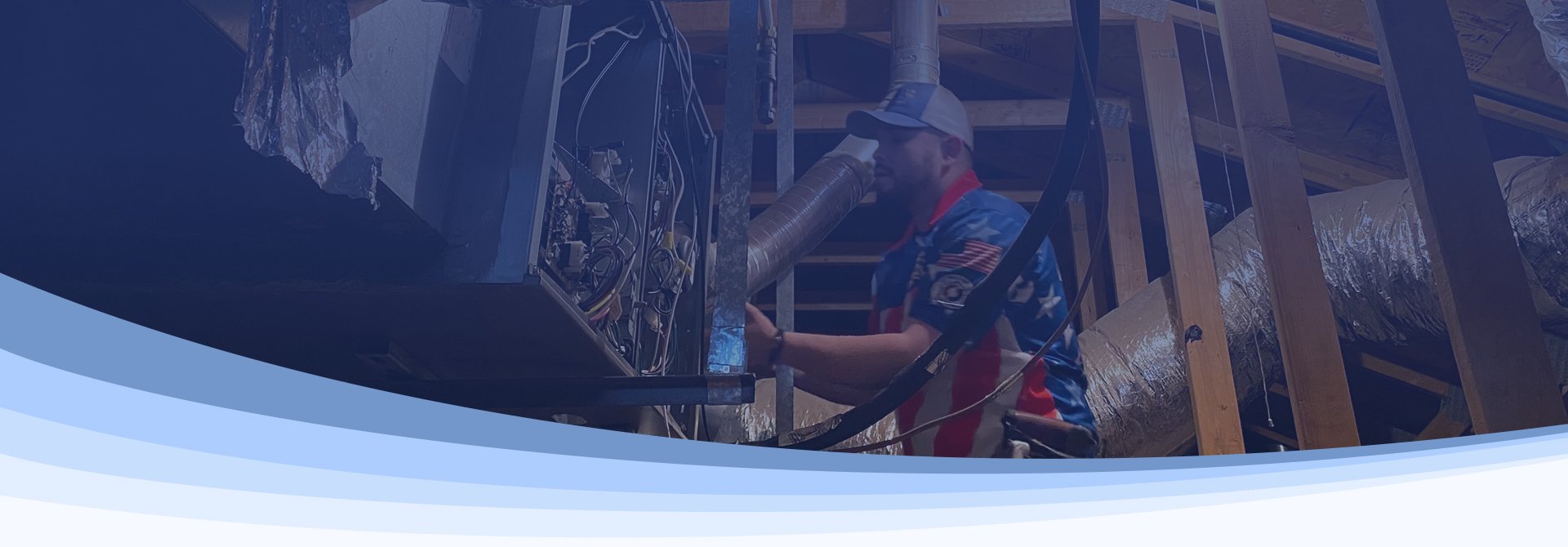 An Autumn Air technician working on ductwork and an air handler in a home's attic.